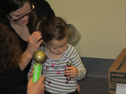 A blind child is listening to the sound maker as part of the tactile learning process